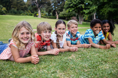 Happy children lying on grass