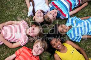 Happy children lying on grass