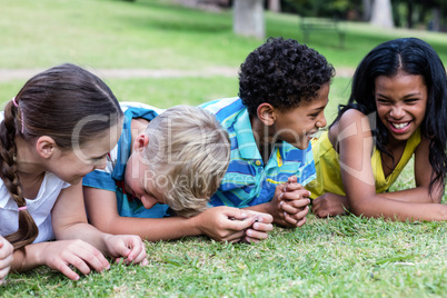 Happy children lying on grass