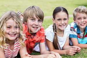 Happy children lying on grass