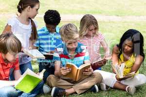Children reading book in the park
