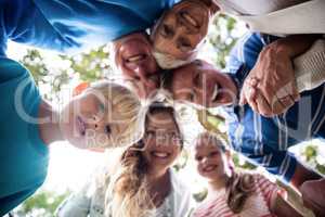 Portrait of happy multi-generation family forming a huddle in pa