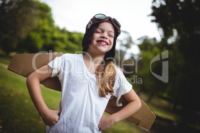 Happy girl standing in the park with hand on hip