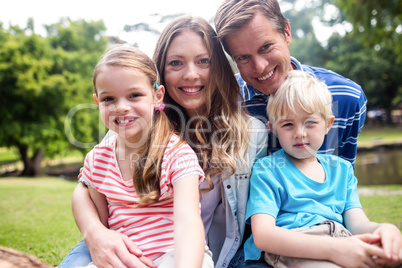 Happy family sitting together in the park