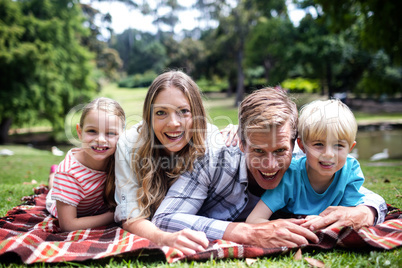 Happy family lying in the park