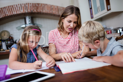 Mother helping kids with their homework