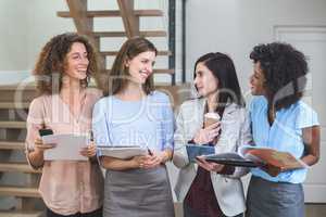 Female business colleagues standing together with file and digit