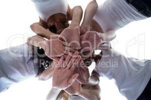Women in a circle putting their hands together