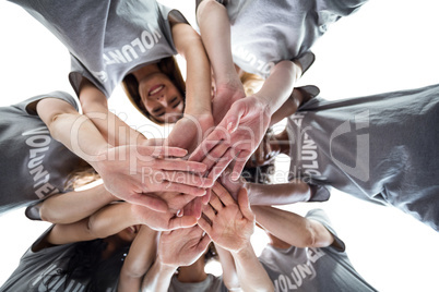 Happy volunteers in a circle putting their hands together