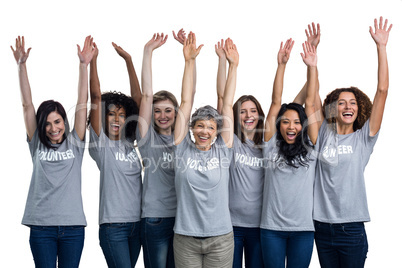Portrait of happy volunteers standing with hands raised
