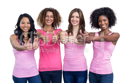 Women in pink outfits showing their thumbs up