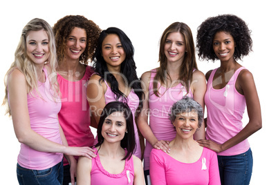 Smiling women in pink outfits posing for breast cancer awareness