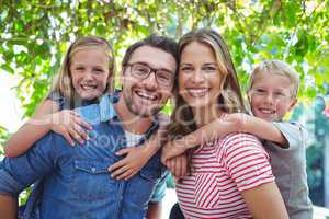 Happy parents giving piggy back to children