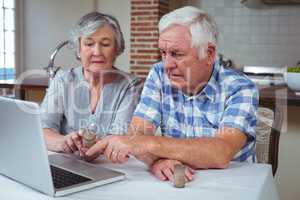 Senior couple searching pills with help of laptop
