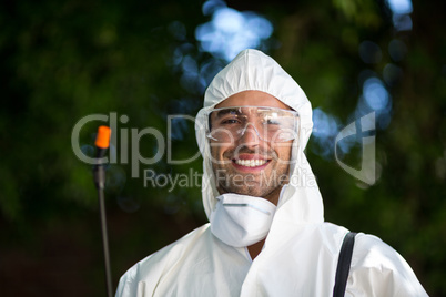 Close-up portrait of smiling man with pesticide sprayer