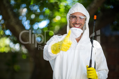 Man showing thumbs up while holding insecticide sprayer