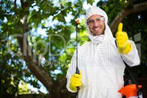 Smiling man showing thumbs up while holding insecticide