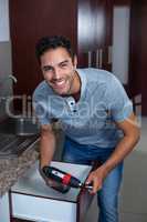 Worker using hand drill on drawer