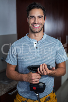Portrait of cheerful man holding cordless hand drill