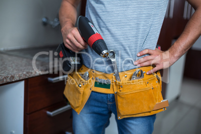 Midsection of man holding cordless hand drill