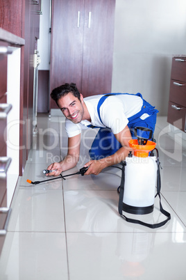 Cheerful man using torch while spraying insecticide