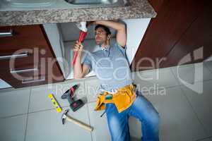 High angle view of man fixing sink pipe