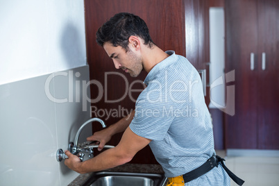 Man fixing faucet with wrench