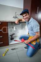 Portrait of happy man holding pipe wrench