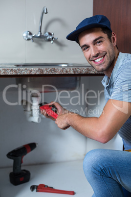 Portrait of man using pipe wrench