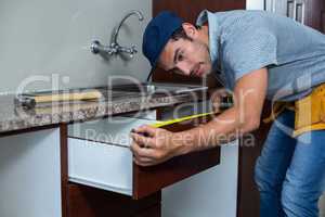 Man measuring drawer size