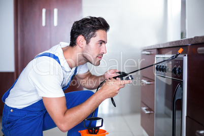 Man spraying insecticide on oven