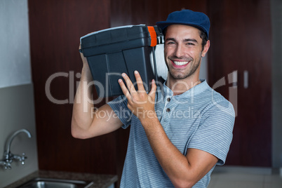 Portrait of smiling man carrying toolbox