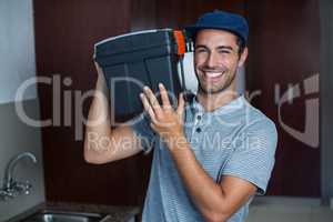 Portrait of smiling man carrying toolbox