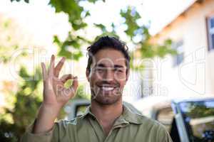 Portrait of smiling pesticide worker showing ok sign