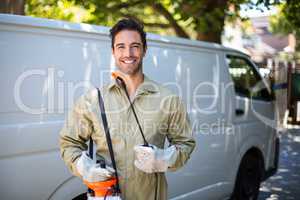 Smiling worker with pesticide sprayer