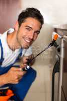 Cheerful man spraying insecticide on oven