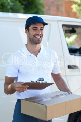 Happy delivery man with clipboard and cardboard box