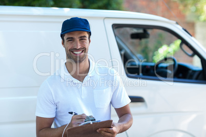 Portrait of happy delivery man with clipboard