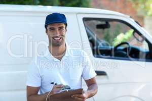 Portrait of happy delivery man with clipboard