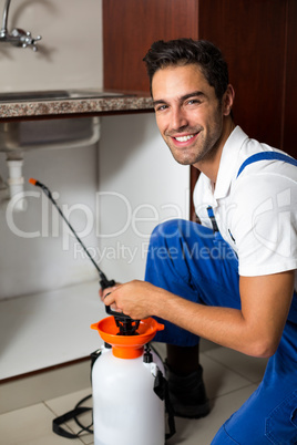 Portrait of cheerful man spraying insecticide