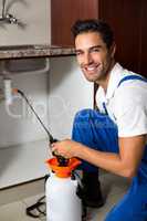 Portrait of cheerful man spraying insecticide