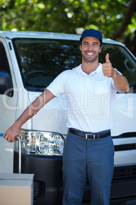 Portrait of happy delivery man showing thumbs up