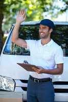 Smiling delivery man waving hand