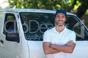 Portrait of cheerful delivery man with arms crossed