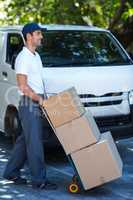 Side view of delivery man carrying cardboard boxes