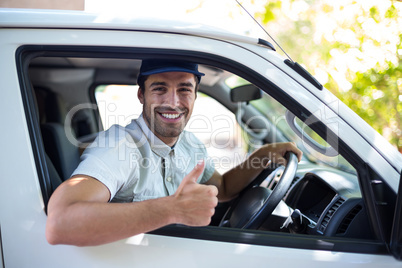 Cheerful delivery man showing thumbs up