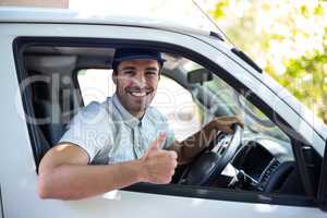 Cheerful delivery man showing thumbs up