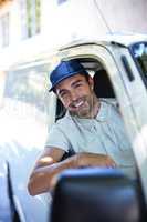 Smiling delivery person sitting in van