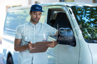 Delivery person looking at clipboard
