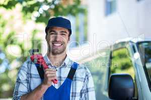 Portrait of happy carpenter holding pipe wrench
